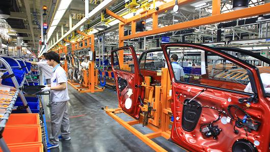 Employees work in a plant of FAW-Volkswagen Automotive Company on September 25, 2013 in Foshan, China.